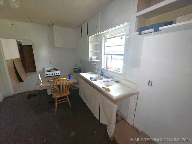 kitchen featuring dark carpet, tile countertops, and white cabinetry