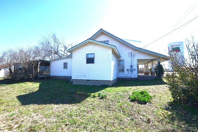 back of house featuring a sunroom and a lawn