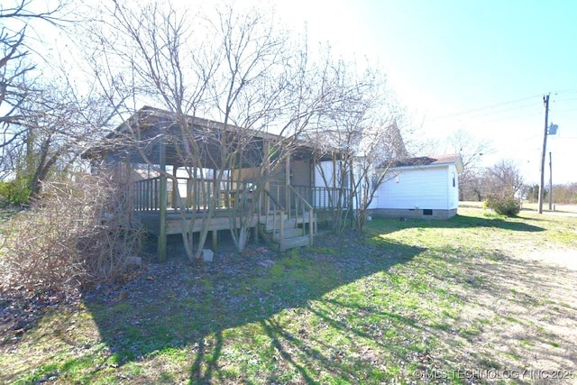 back of property featuring a deck and a lawn