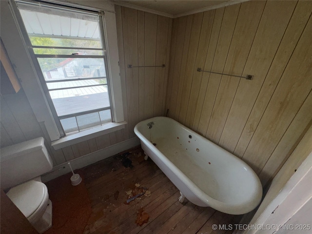 full bathroom with toilet, wood walls, a freestanding tub, and hardwood / wood-style flooring