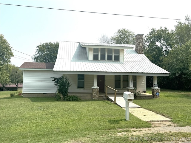 view of front of house with covered porch, metal roof, a chimney, and a front yard