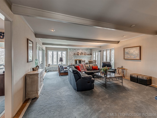 carpeted living room featuring ornamental molding, beam ceiling, and a stone fireplace