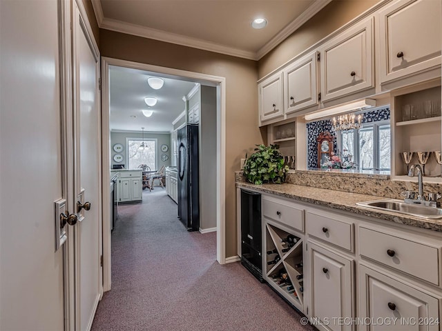 hall with a sink, baseboards, a notable chandelier, dark carpet, and ornamental molding