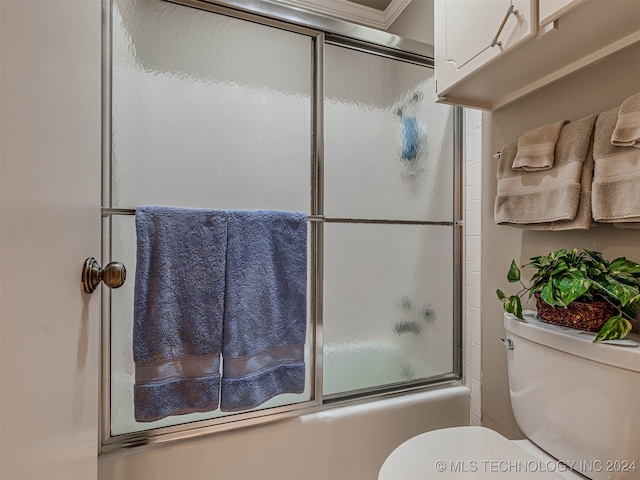 bathroom featuring shower / bath combination with glass door, crown molding, and toilet