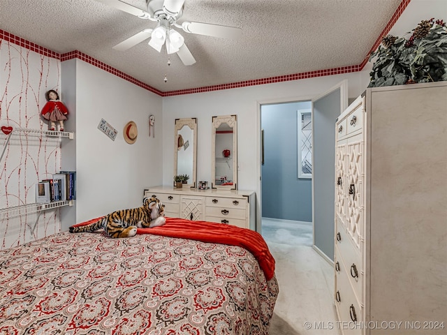 bedroom featuring a closet, ceiling fan, carpet, and a textured ceiling