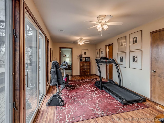 workout area with ceiling fan, baseboards, wood finished floors, and visible vents