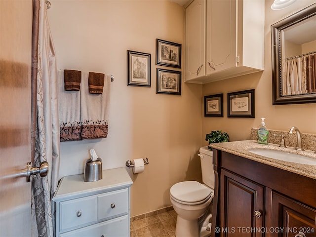 bathroom with tile patterned flooring, vanity, and toilet