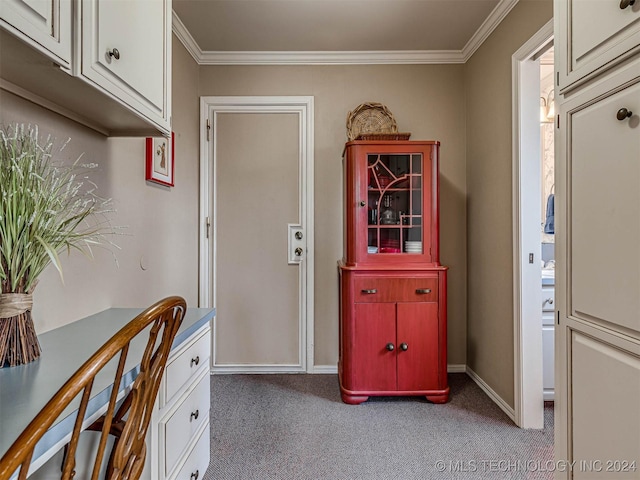 carpeted entryway with crown molding and baseboards