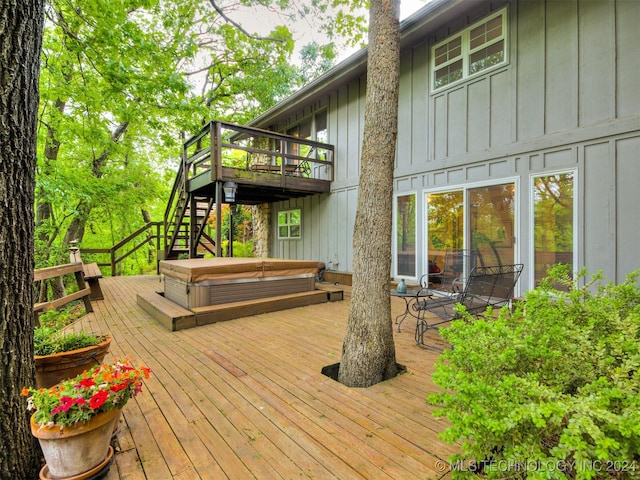 wooden deck with a covered hot tub and stairway