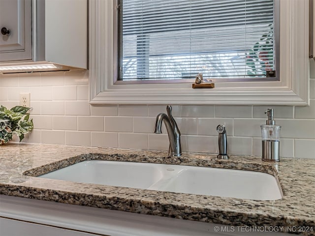 details with tasteful backsplash, light stone counters, and a sink