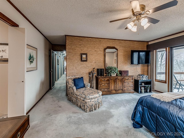 carpeted bedroom with a ceiling fan, a textured ceiling, and ornamental molding