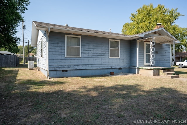 view of front of house with cooling unit and a front lawn