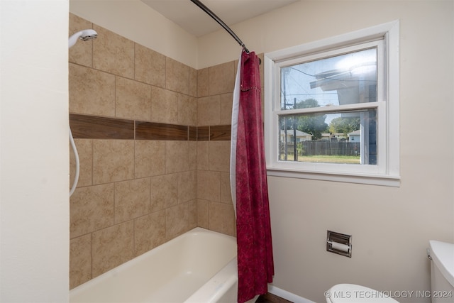 bathroom with shower / tub combo with curtain and toilet