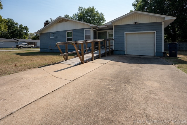 ranch-style home featuring a wooden deck, a garage, and a front lawn