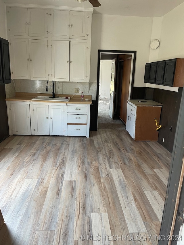 kitchen featuring ceiling fan, white cabinetry, light wood-type flooring, and sink