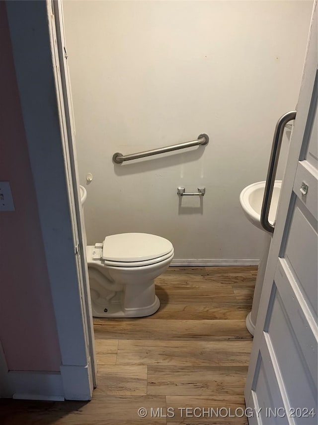 bathroom with hardwood / wood-style flooring and toilet