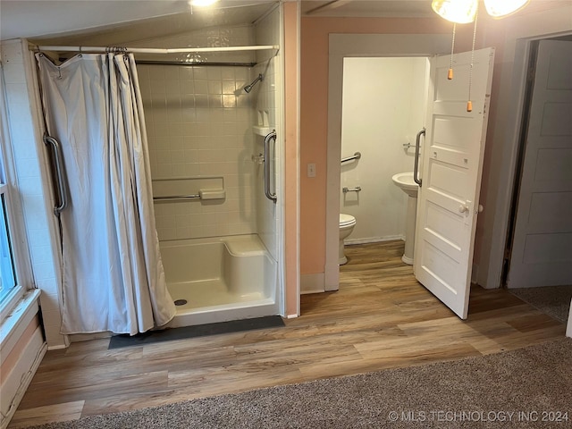 bathroom featuring a shower with curtain, hardwood / wood-style floors, and toilet