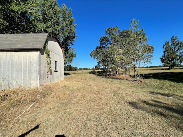 view of yard with an outdoor structure and a rural view