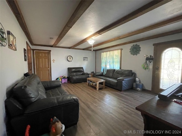 living room with beam ceiling, visible vents, and wood finished floors