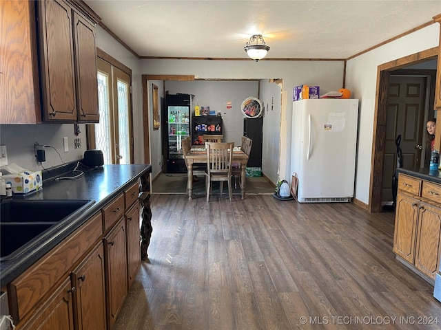 kitchen featuring freestanding refrigerator, dark wood-style flooring, and dark countertops