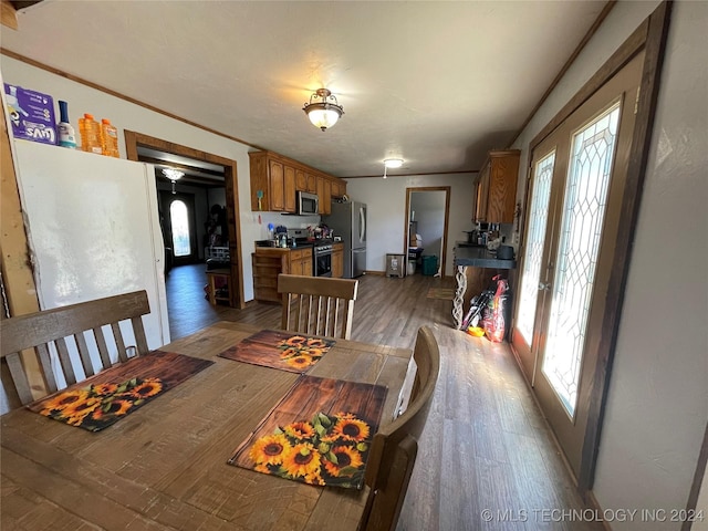 dining space featuring dark wood-style floors, french doors, and ornamental molding