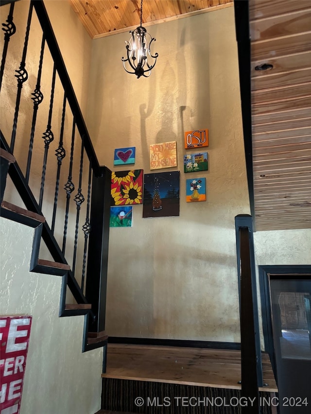 staircase featuring wood ceiling and a chandelier