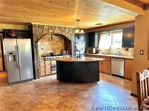 kitchen with tile patterned floors, a center island, stainless steel appliances, and wooden ceiling