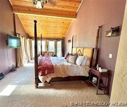 bedroom with a wood stove, wood ceiling, vaulted ceiling, and carpet floors