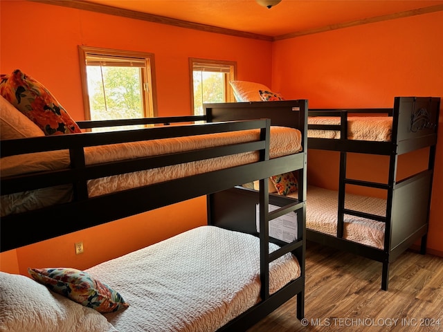 bedroom with ornamental molding and wood-type flooring