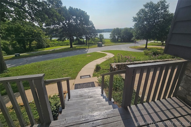 wooden deck with a water view and a yard