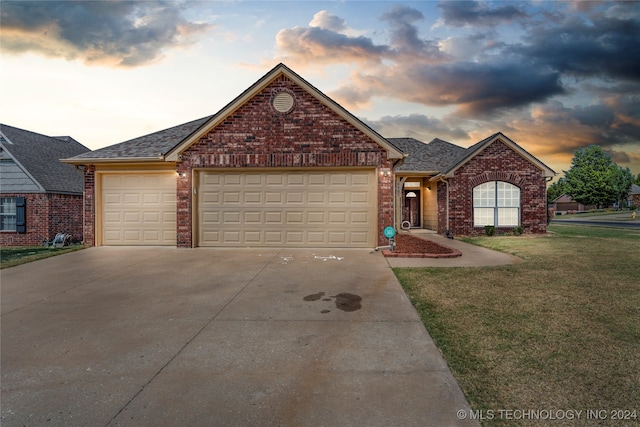 view of front of house featuring a garage and a lawn