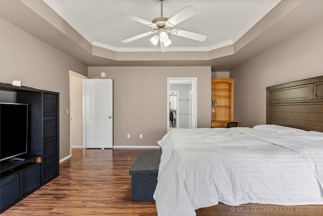 bedroom featuring dark wood-type flooring, ceiling fan, ornamental molding, and a tray ceiling