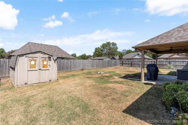 view of yard with ceiling fan, a shed, and a patio area