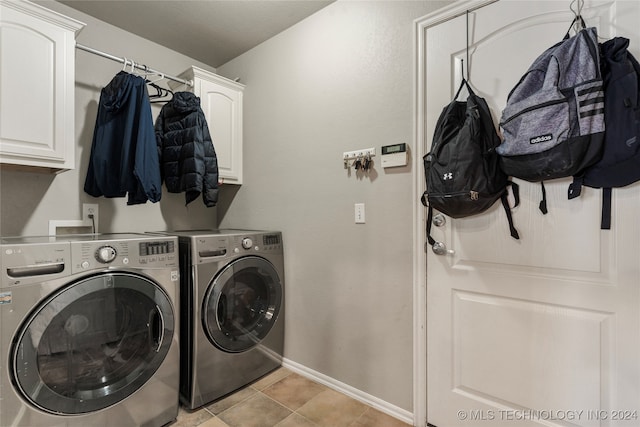 laundry room featuring light tile patterned flooring, cabinets, and separate washer and dryer