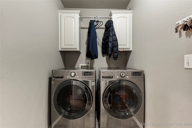 clothes washing area featuring independent washer and dryer and cabinets