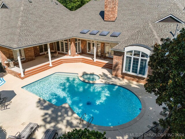 view of swimming pool featuring a patio area, french doors, and an in ground hot tub