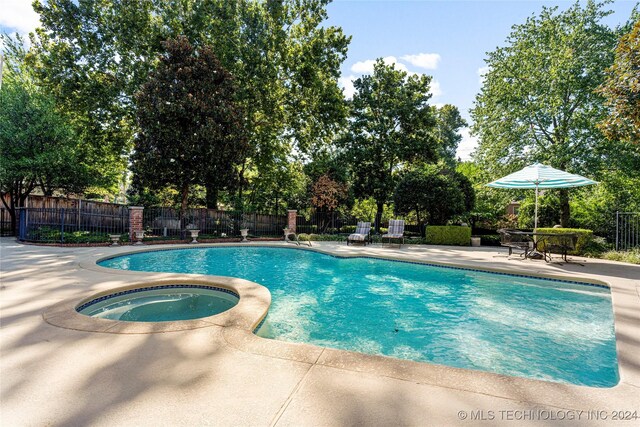 view of pool with an in ground hot tub and a patio area