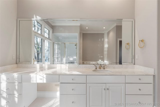 bathroom with crown molding, vanity, and walk in shower