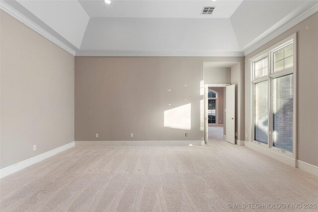 empty room featuring a raised ceiling, ornamental molding, lofted ceiling, and light carpet