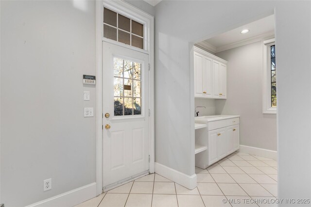 laundry area featuring light tile patterned flooring, sink, and ornamental molding