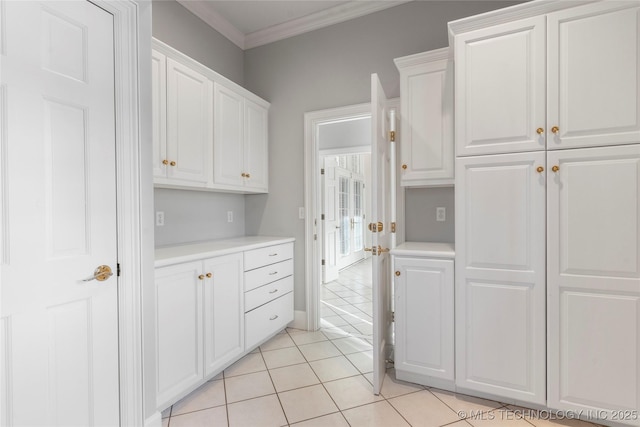 kitchen featuring crown molding, light tile patterned floors, and white cabinets