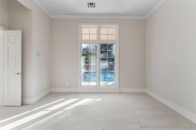 unfurnished room with ornamental molding and light colored carpet