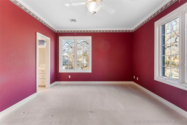 carpeted spare room with plenty of natural light and ceiling fan