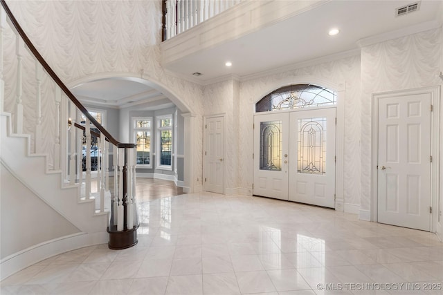 foyer featuring crown molding and french doors