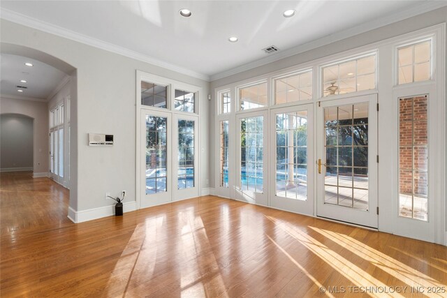 entryway with crown molding, wood-type flooring, and french doors