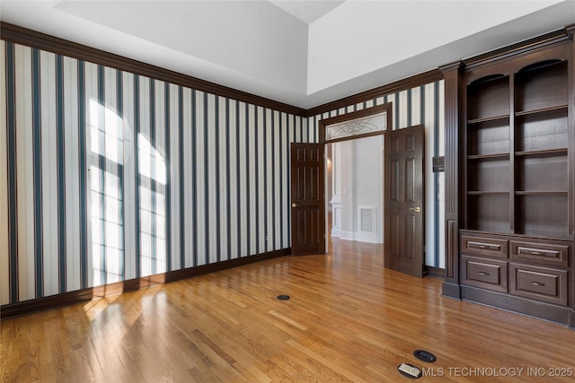 unfurnished room featuring wood-type flooring and built in features