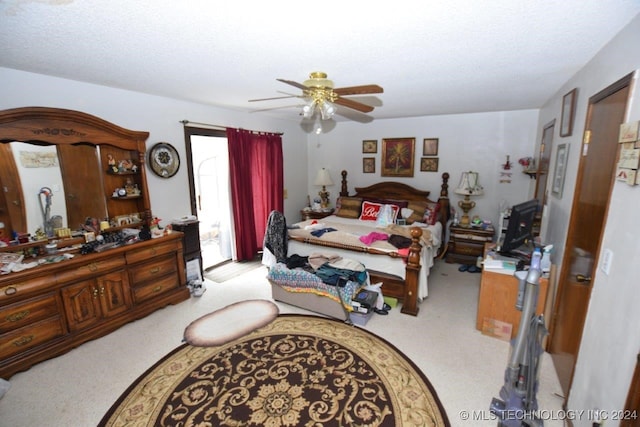 carpeted bedroom with a textured ceiling and ceiling fan