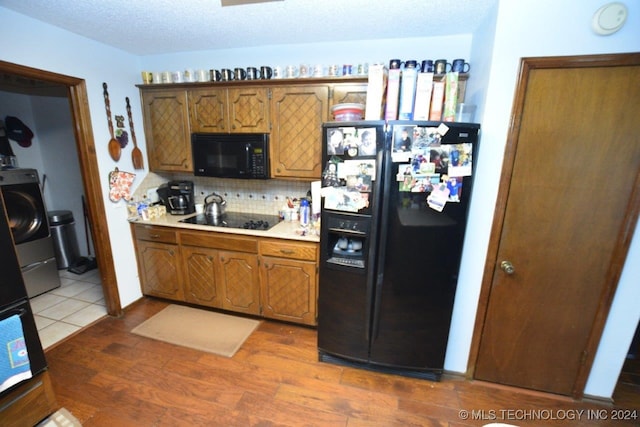 kitchen with black appliances, dark hardwood / wood-style flooring, tasteful backsplash, and a textured ceiling