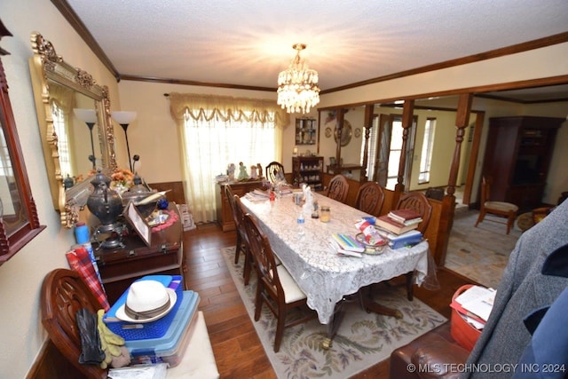 dining space featuring ornamental molding, a notable chandelier, hardwood / wood-style flooring, and a textured ceiling