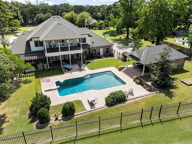 view of swimming pool featuring a lawn, a patio area, and a diving board